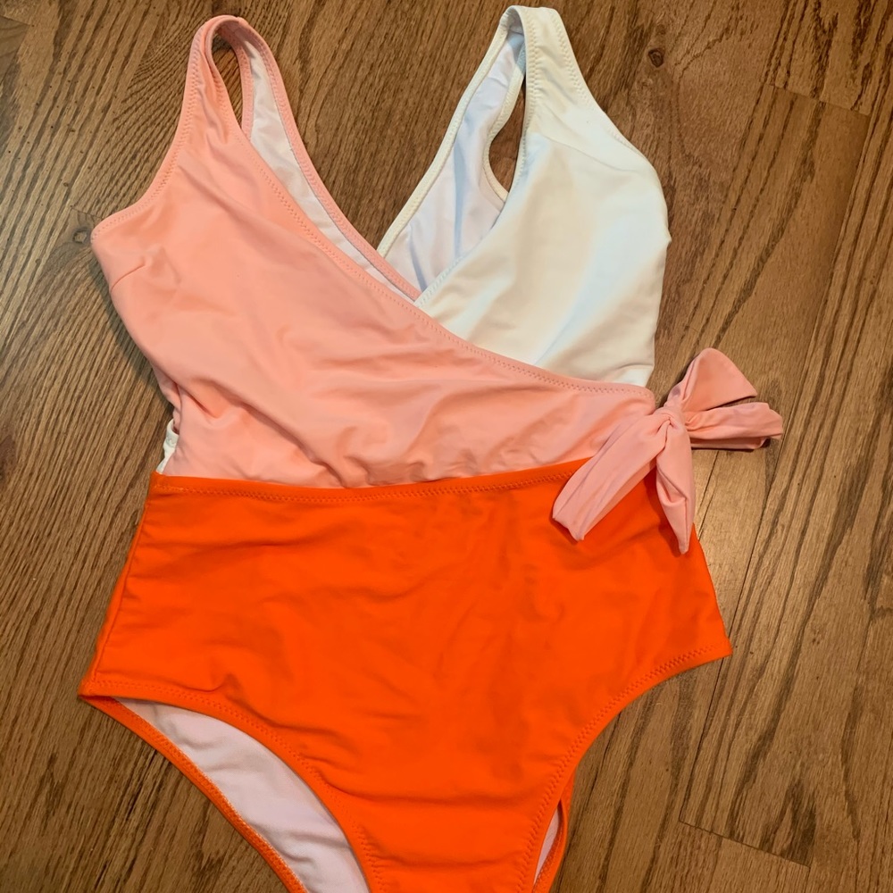 Peach, orange, and white one piece bathing suit
